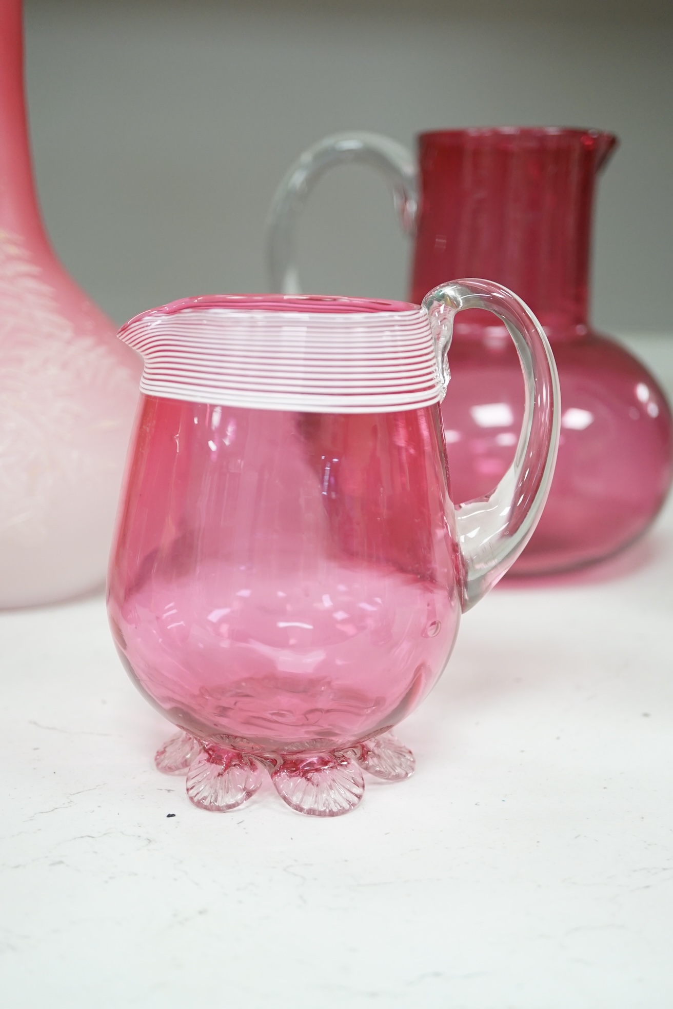 A pair of Victorian pink satin long necked vases, 25cm high, and five pieces of cranberry coloured glassware, (8). Condition - fair to good.